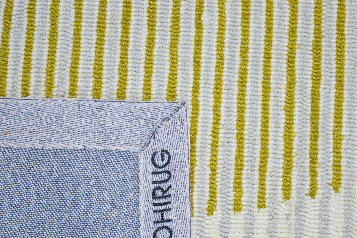 Hupe striped hand tufted wool rug, showing back side of rug
