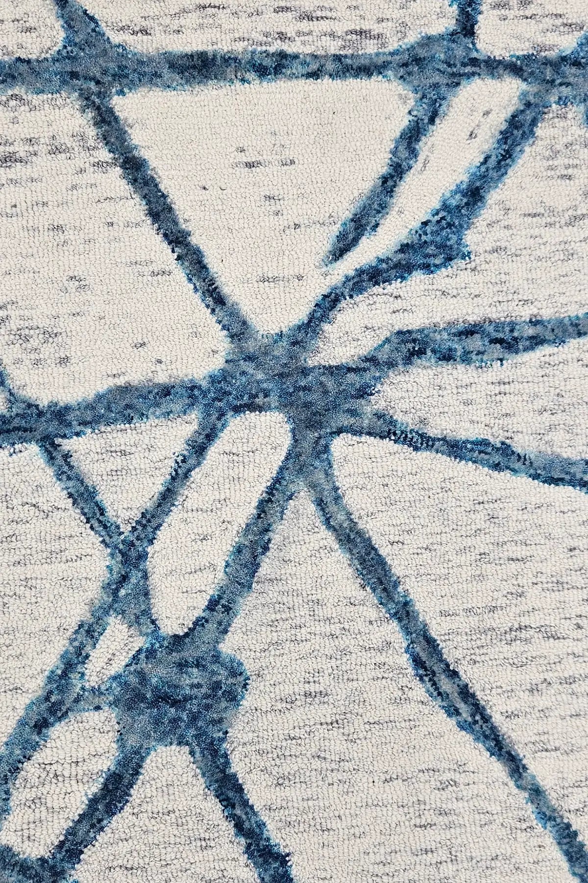 Close-up of a textured hand tufted abstract patterned wool rug with blue and gray design