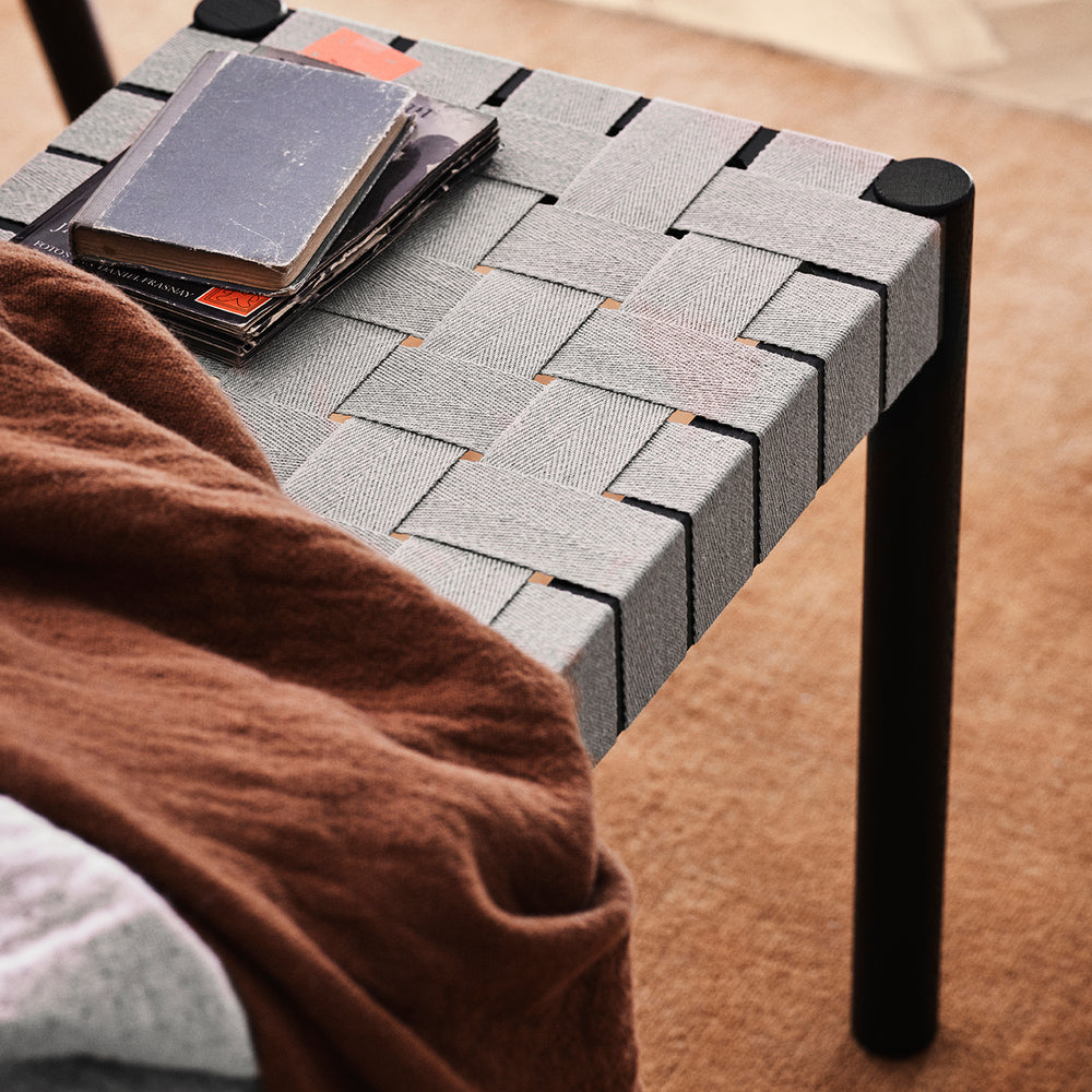 sitting stool on modern wool rug in a rich bronze hue