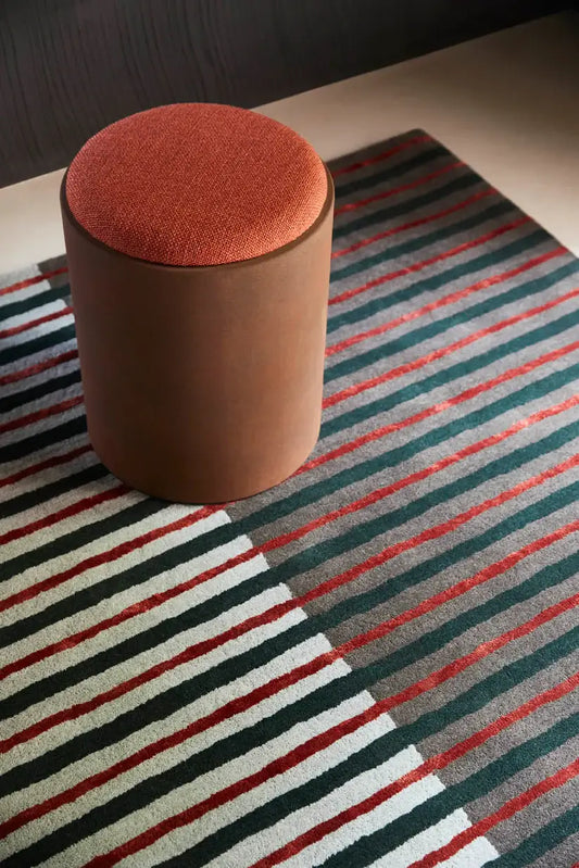 Round brown ottoman on a striped rug