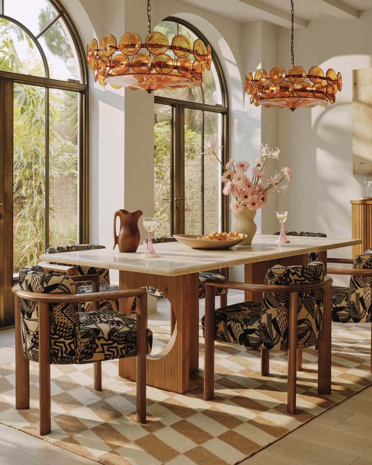 hand woven pettern rug in dining room with wooden table, patterned chairs, and decorative lighting.