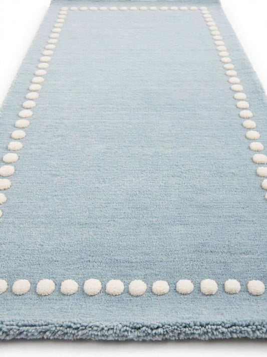 cera tufted area rug with a cream dotted border