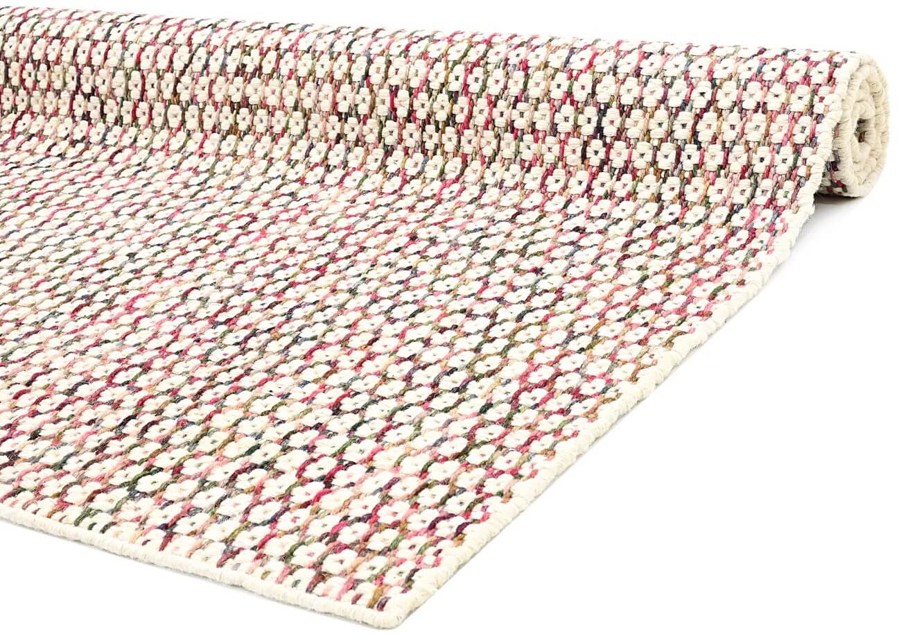 close view of hand woven patterned wool area rug corner