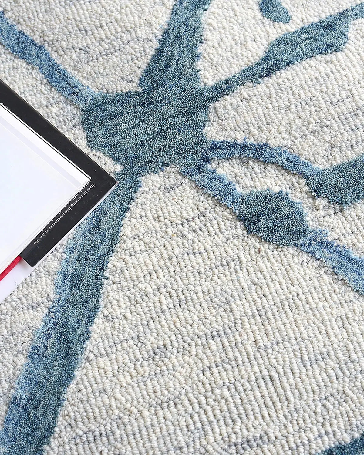 Close-up of a textured wool rug with blue abstract design