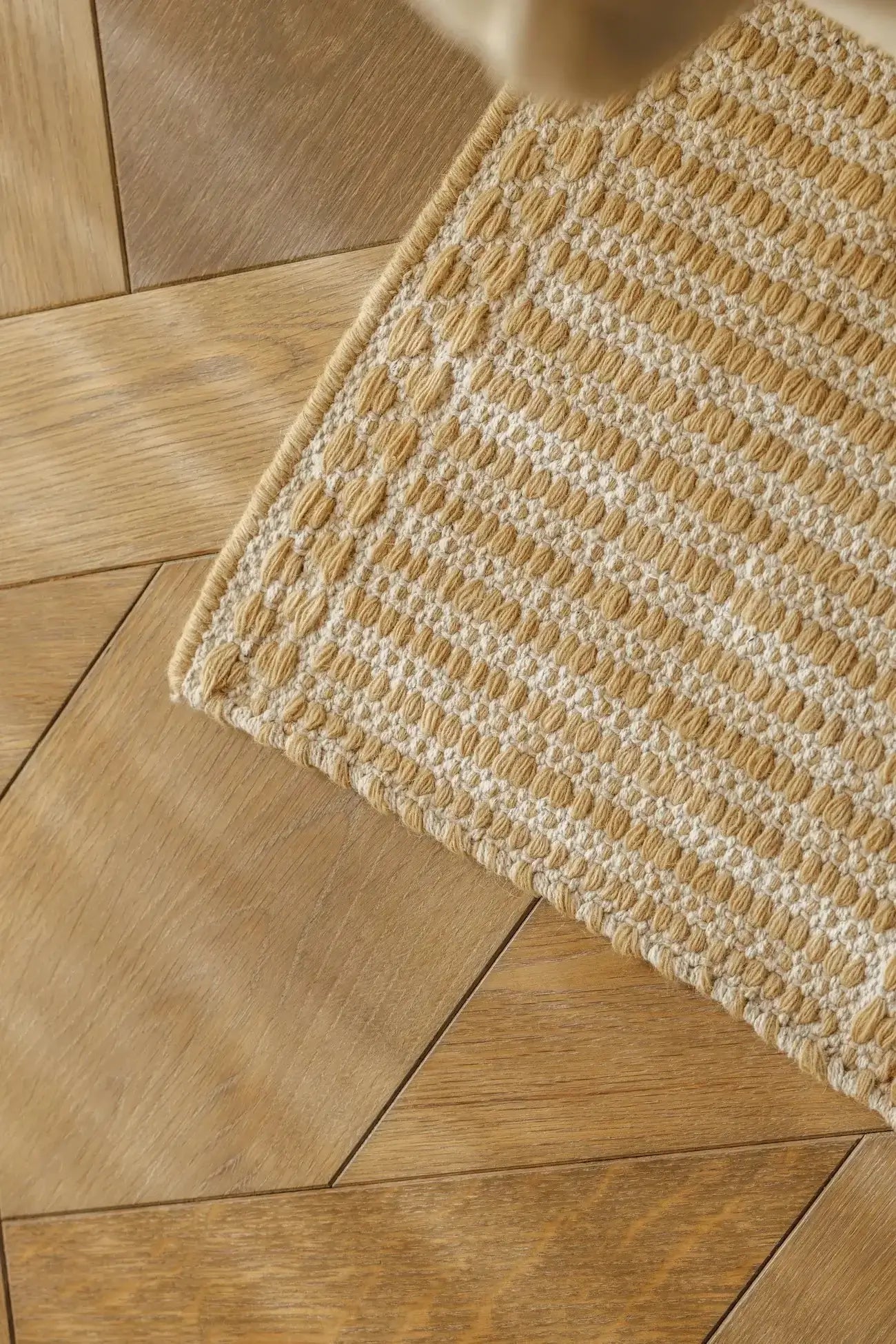 Textured beige hand woven runner on a wooden floor