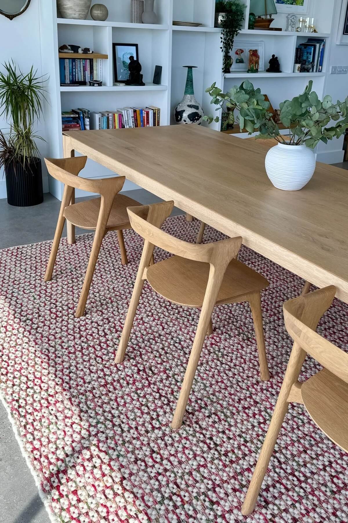 hand woven patterned wool rug in a dining room with shelves and decor.