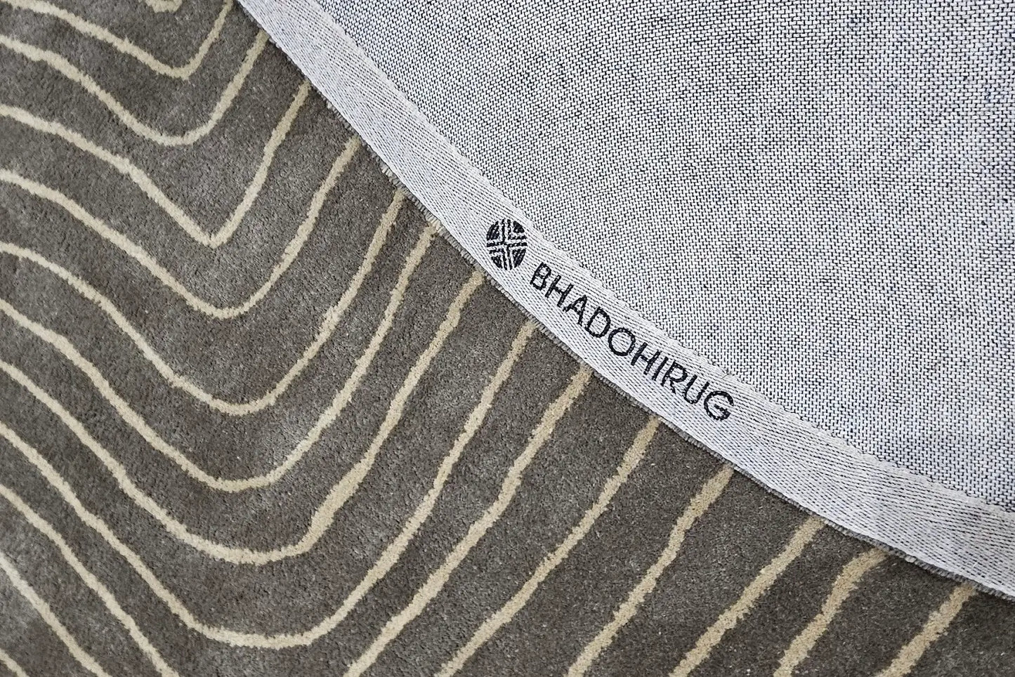 grey round rug, showing backing of the rug