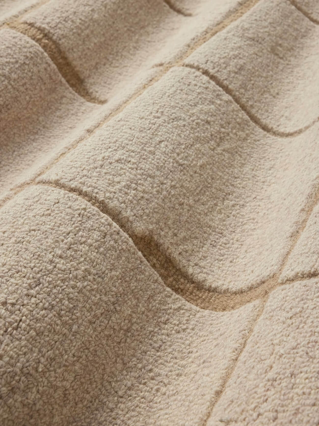 Close-up of a tufted textured beige wool rug