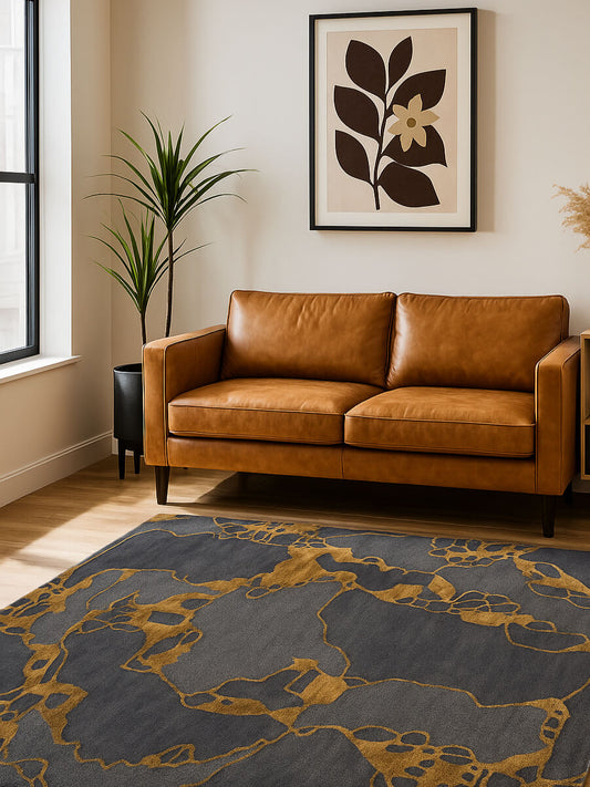 decorative abstract hand tufted wool and silk rug n a rom with brown leather sofa and wall art.