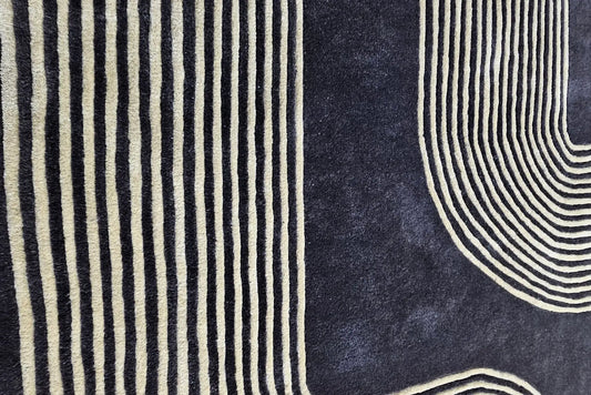 hand tufted wool rug in black with golden strip, close view