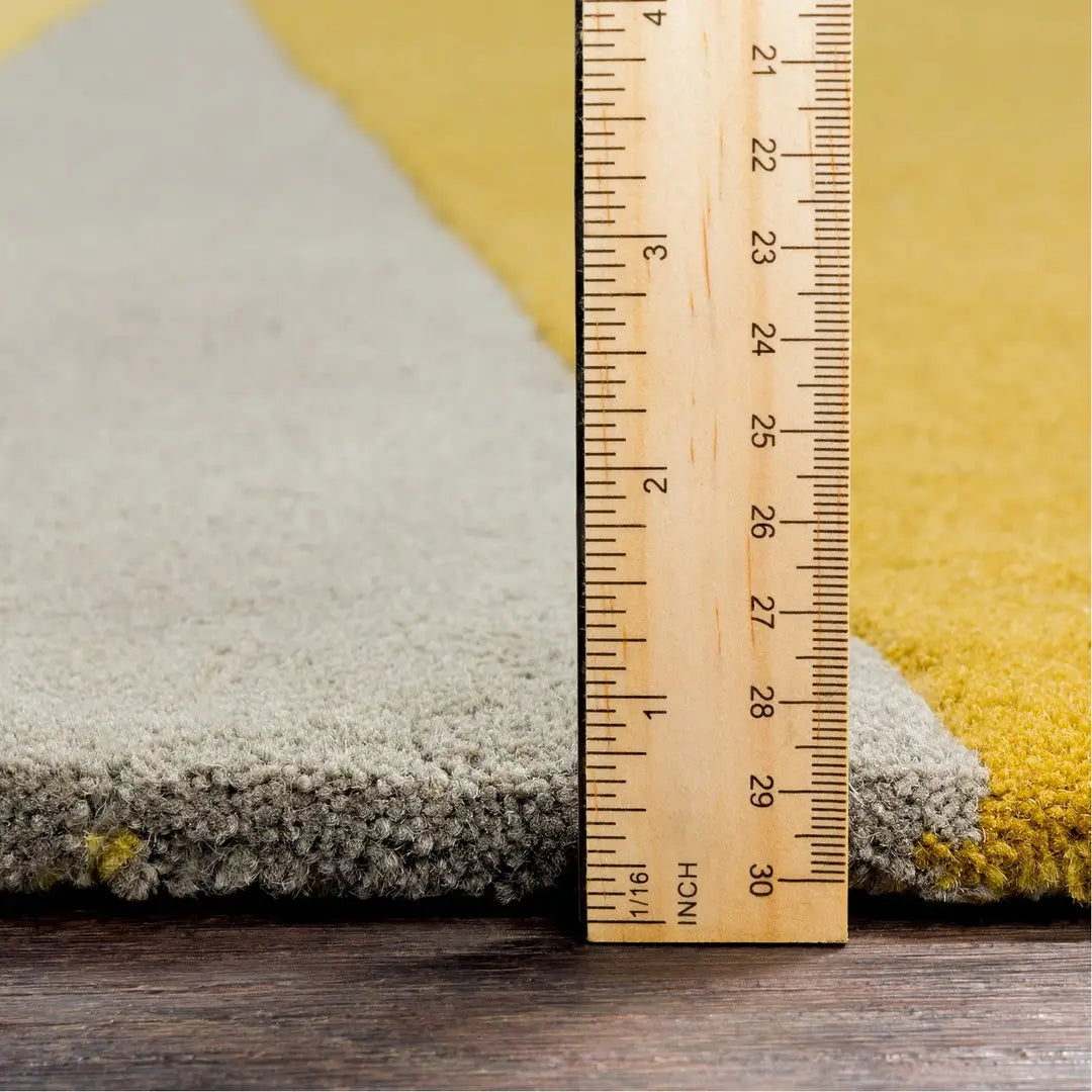 Jarvi hand tufted round shaped rug with ruler showing pile height