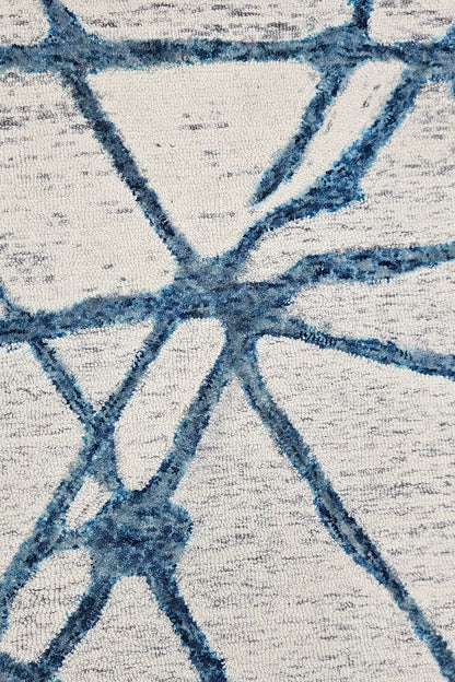Close-up of a textured hand tufted abstract patterned wool rug with blue and gray design
