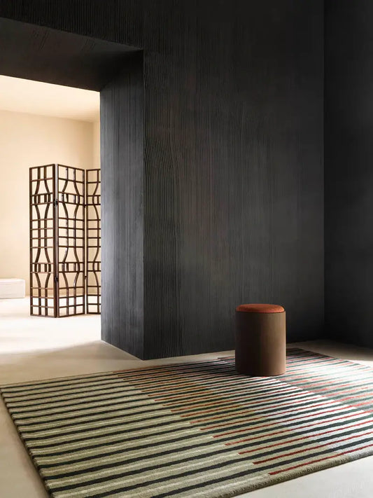 Modern interior with a hand tufted striped wool rug, brown stool