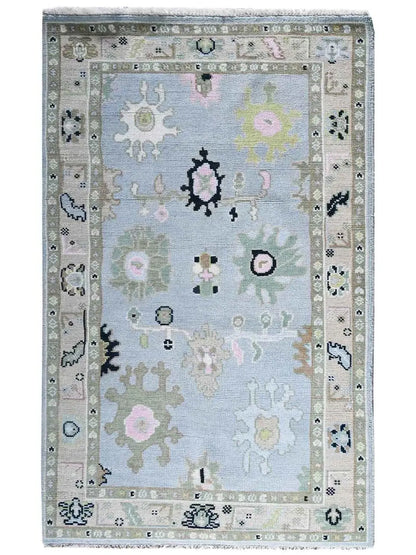 A classic hand knotted area rug with a light blue central field
