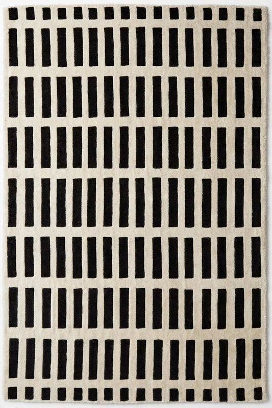 hand tufted area rug with a black and off-white geometric pattern