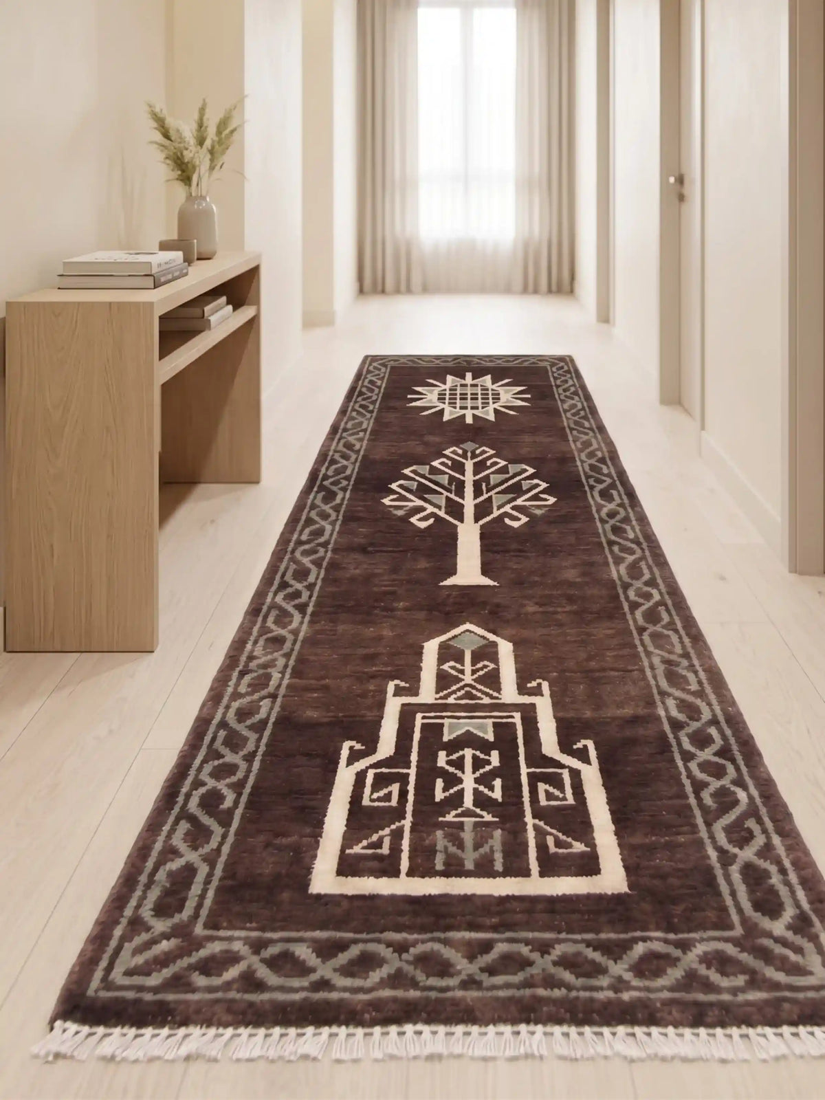 A long runner rug with a dark brown base and cream geometric pattern