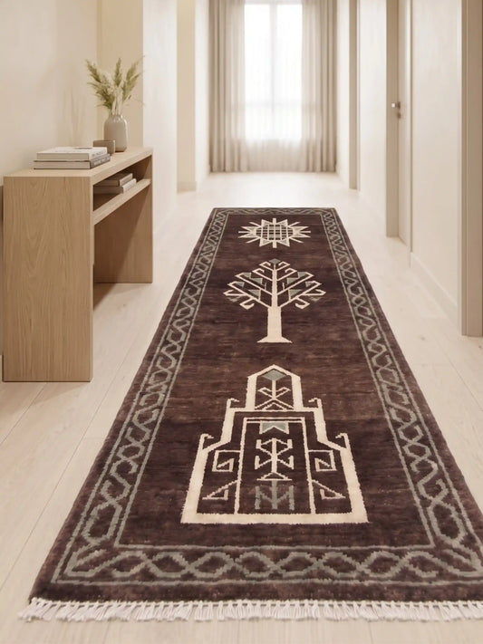 A long runner rug with a dark brown base and cream geometric pattern