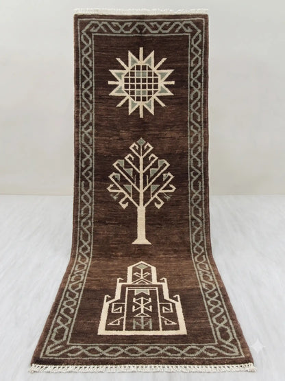 A dark brown hand knotted runner rug