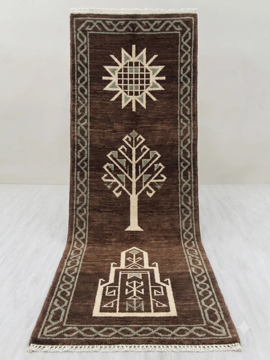 A dark brown hand knotted runner rug