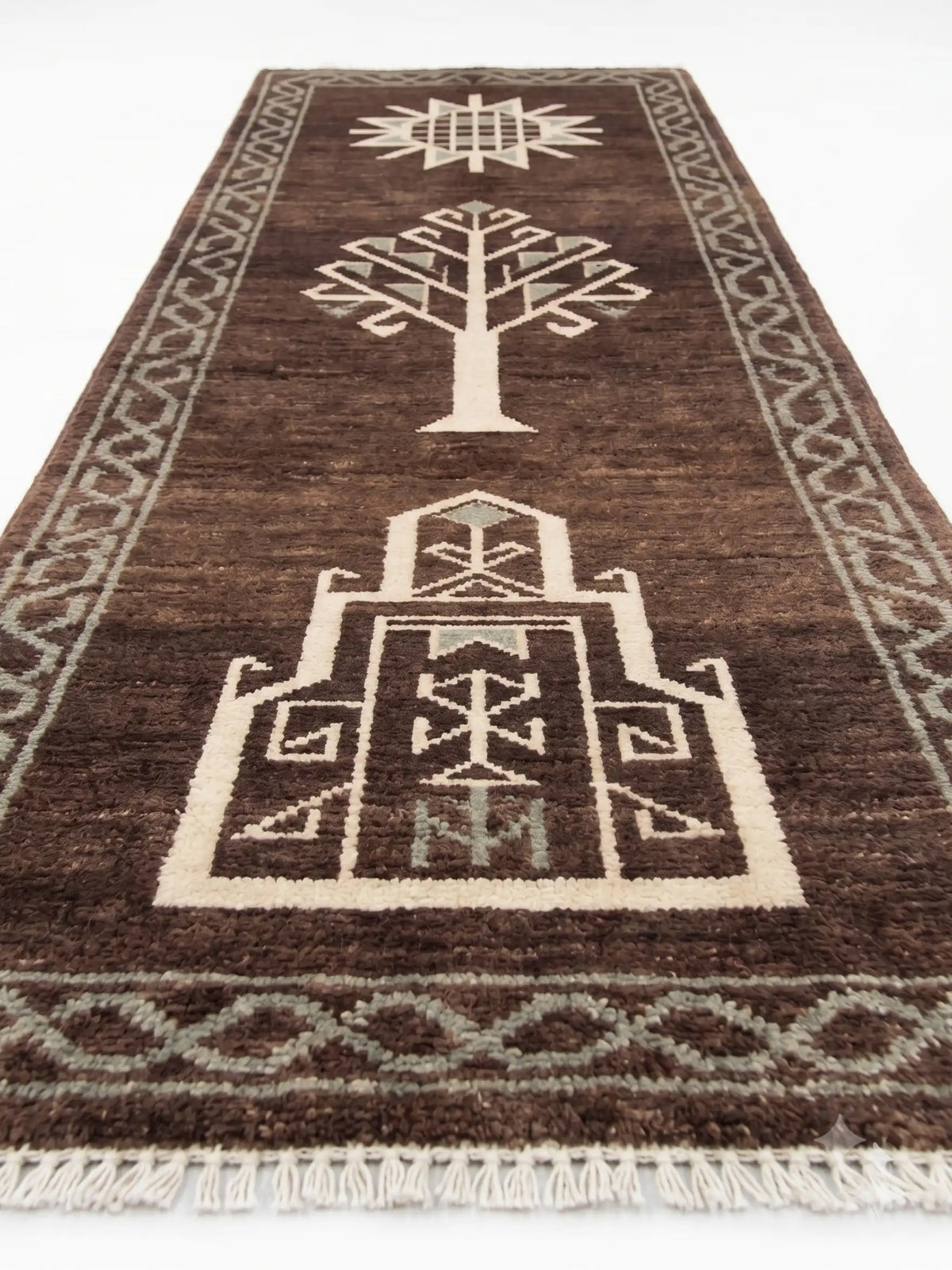 A dark brown wool runner rug