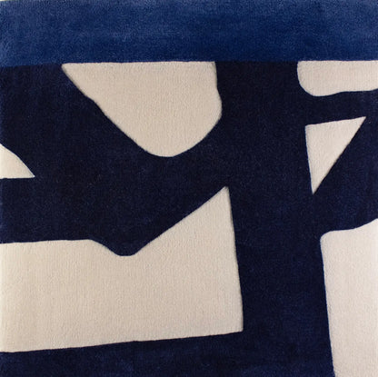 Close-up of a blue patterned wool rug with abstract shapes