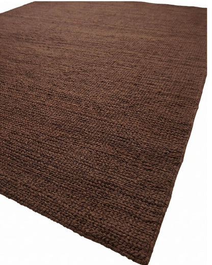 A close-up view of a dark brown textured jute rug, hand woven