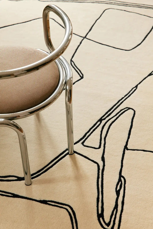 beige hand tufted wool rug with black abstract patterns