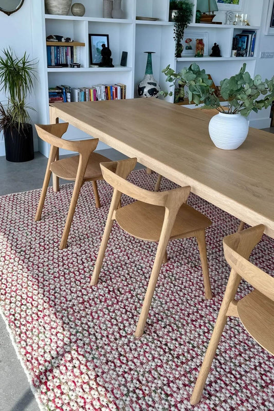 hand woven patterned wool rug in a dining room with shelves and decor.