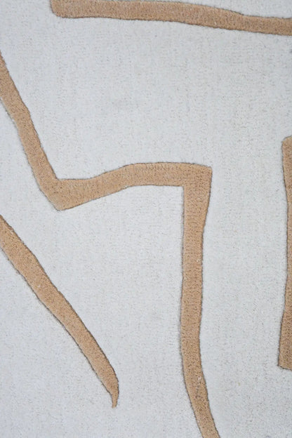 Close-up of modern rug with beige geometric patterns on a light gray background