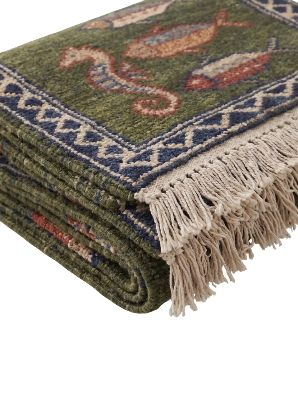 A folded green wool runner rug