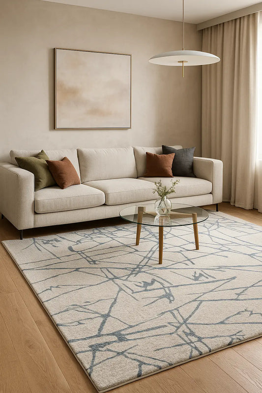 Modern living room with a beige sofa, patterned rug, and decorative pillows.