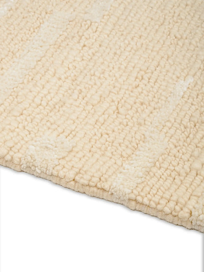 Close-up of a textured beige wool rug