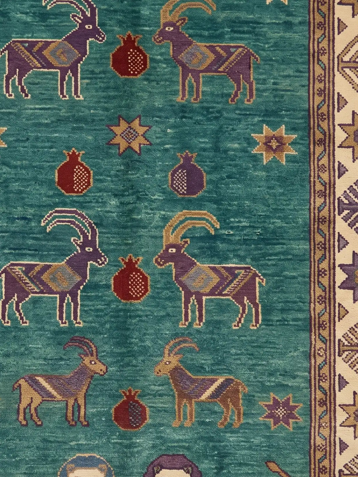 A close-up of a patterned rug featuring stylized goat figures