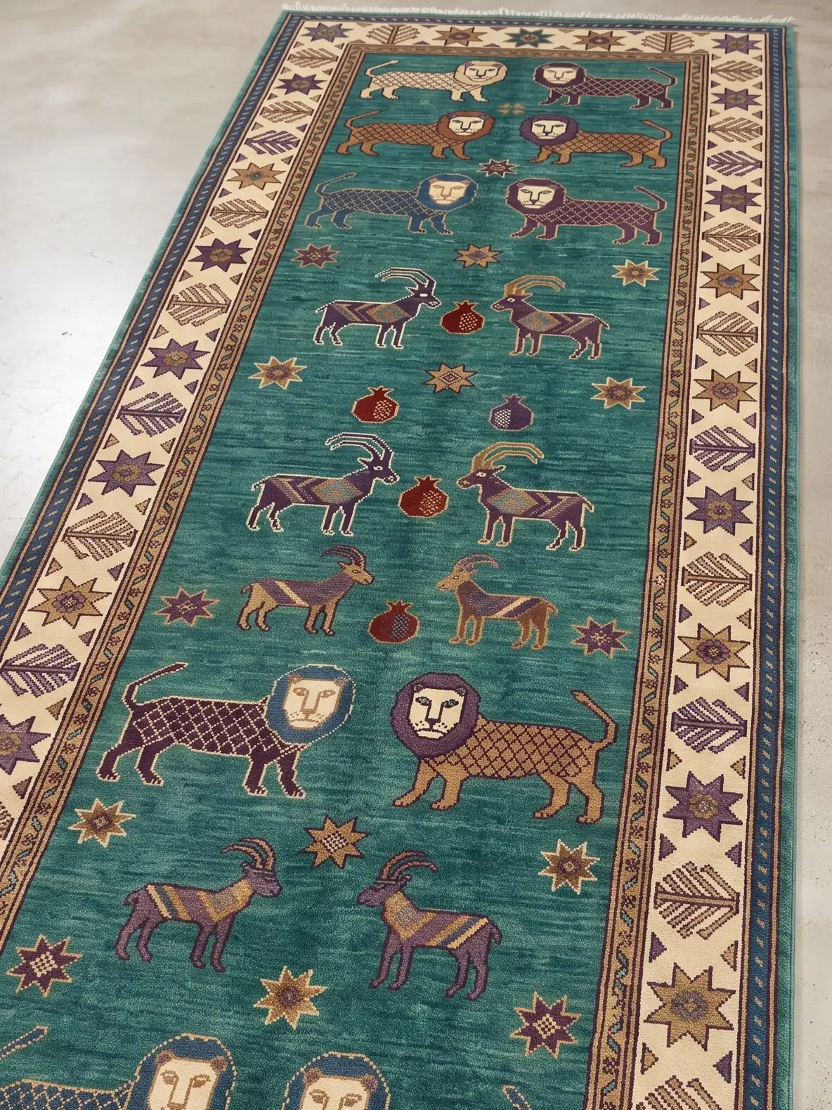 A long runner rug with a teal green field, featuring stylized lions