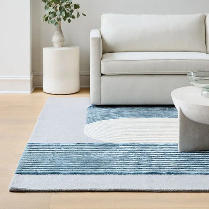 Living room with a blue and gray striped rug, white sofa, and side table.