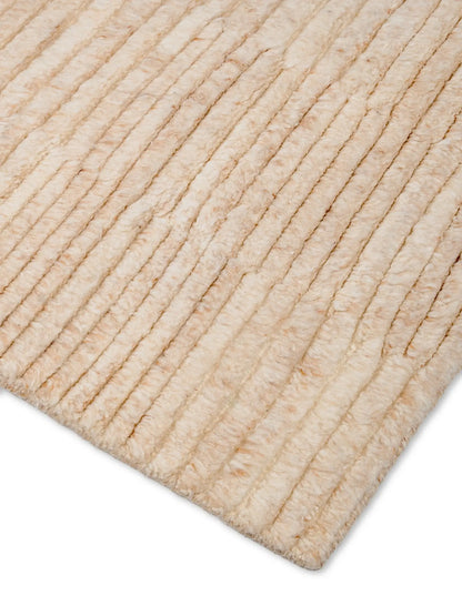 Close-up of a beige textured wool rug corner, hand knotted