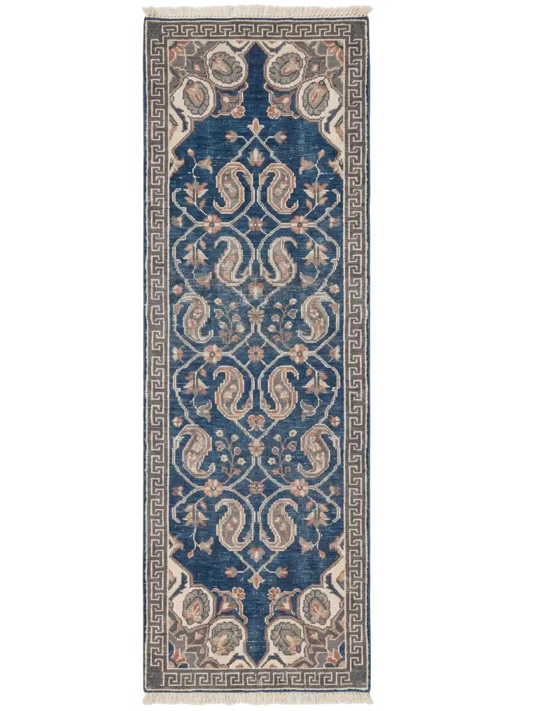 A traditional hand knotted wool runner rug with a deep blue central field