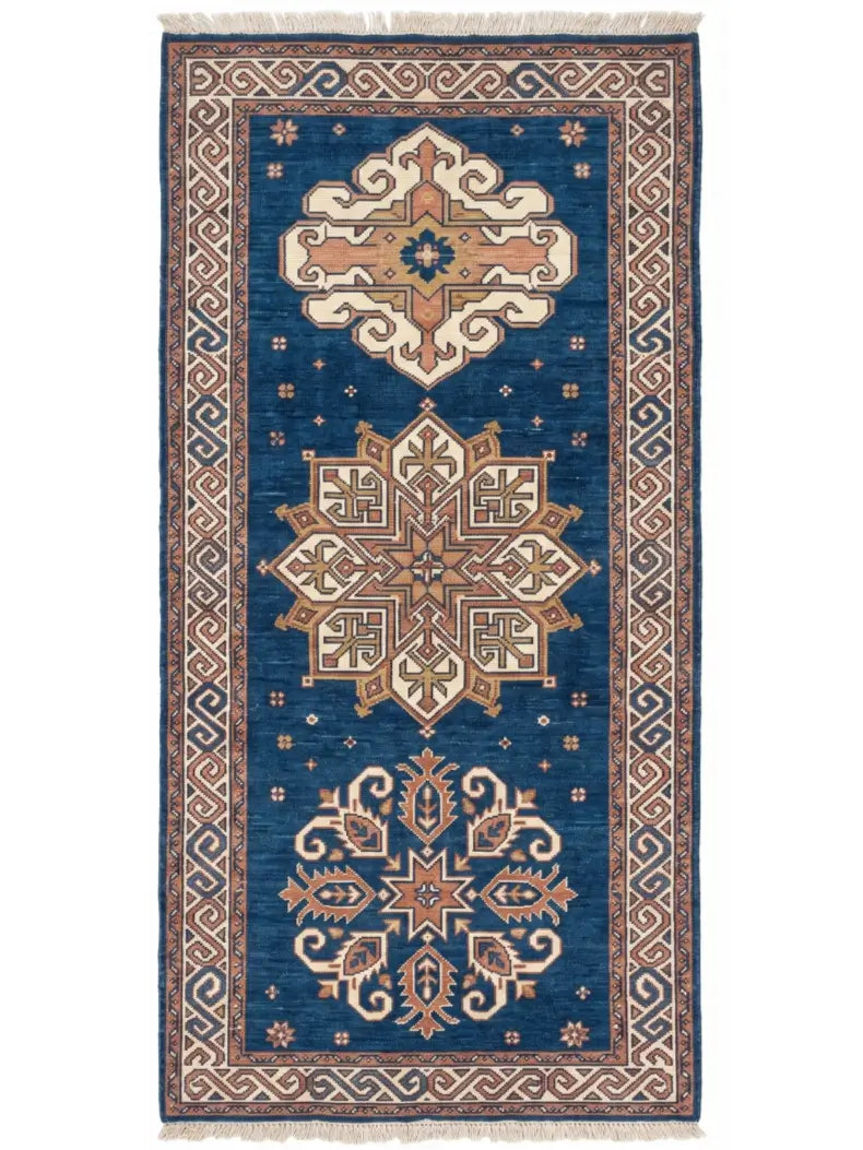 A traditional knotted wool runner rug with a deep blue field