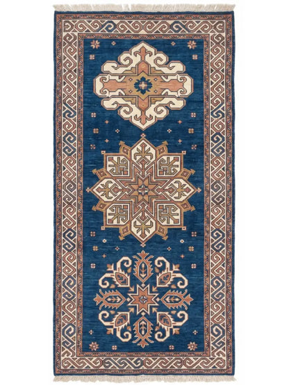 A traditional knotted wool runner rug with a deep blue field