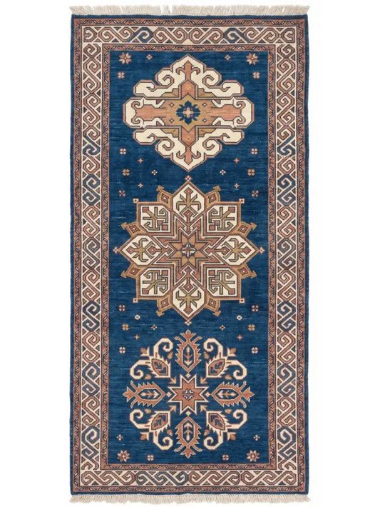 A traditional knotted wool runner rug with a deep blue field