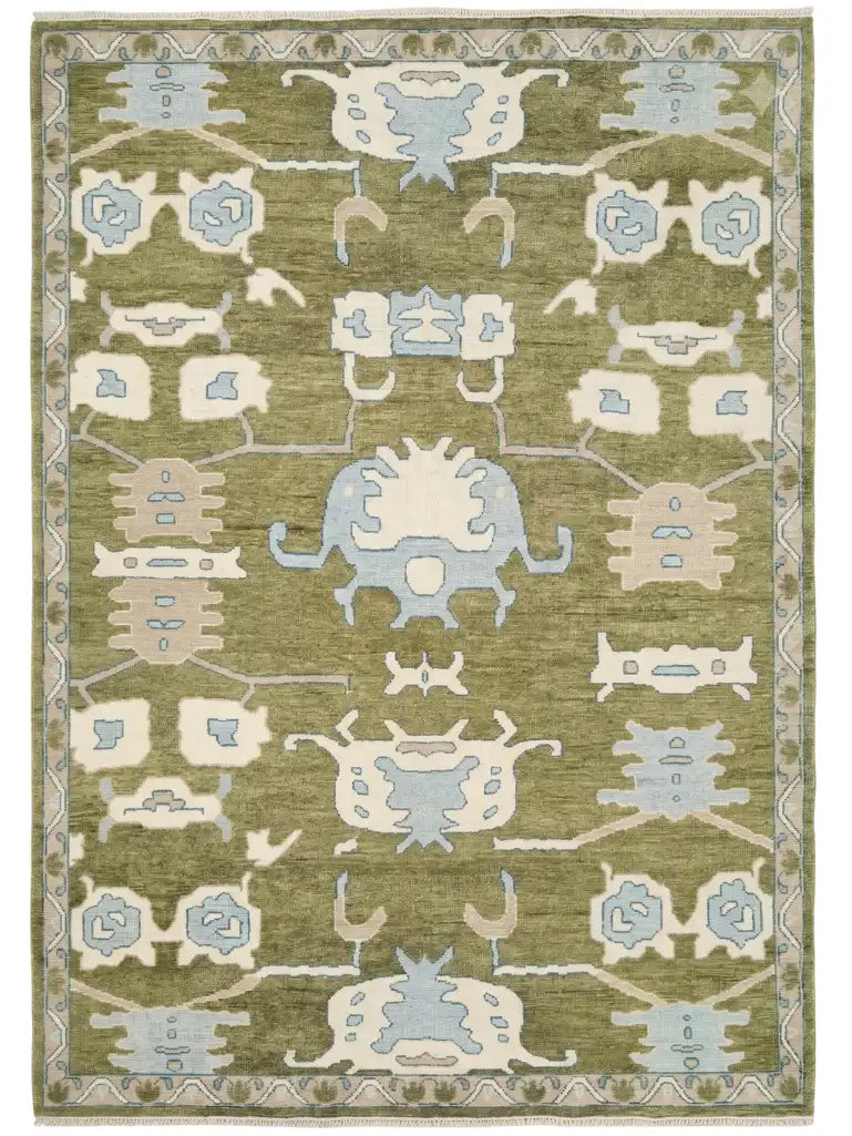 hand knotted area rug with a traditional geometric pattern in sage green