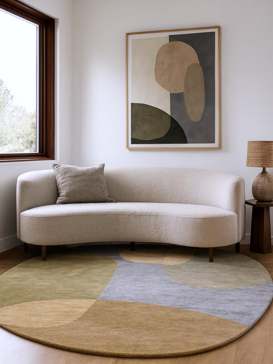 Modern living room with ovel shaped rug, a beige sofa and abstract wall art.
