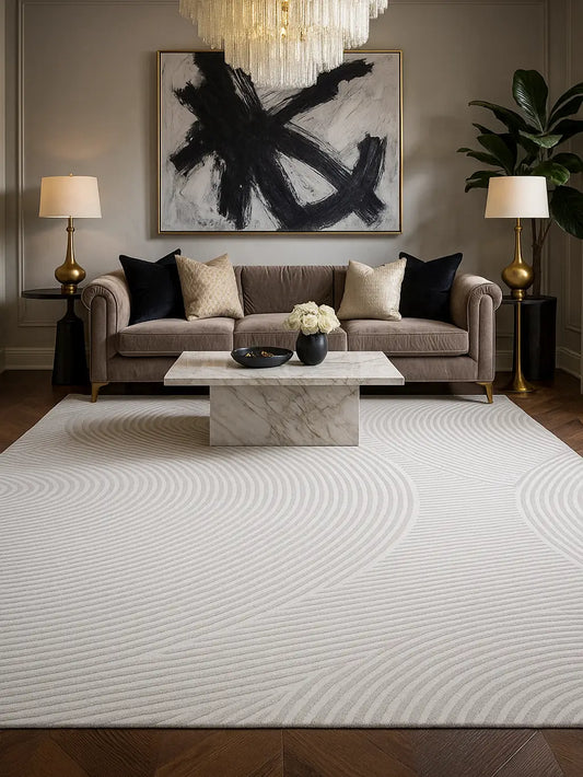 Modern living room with a large white hand tufted wool rug, gray sofa and marble coffee table.