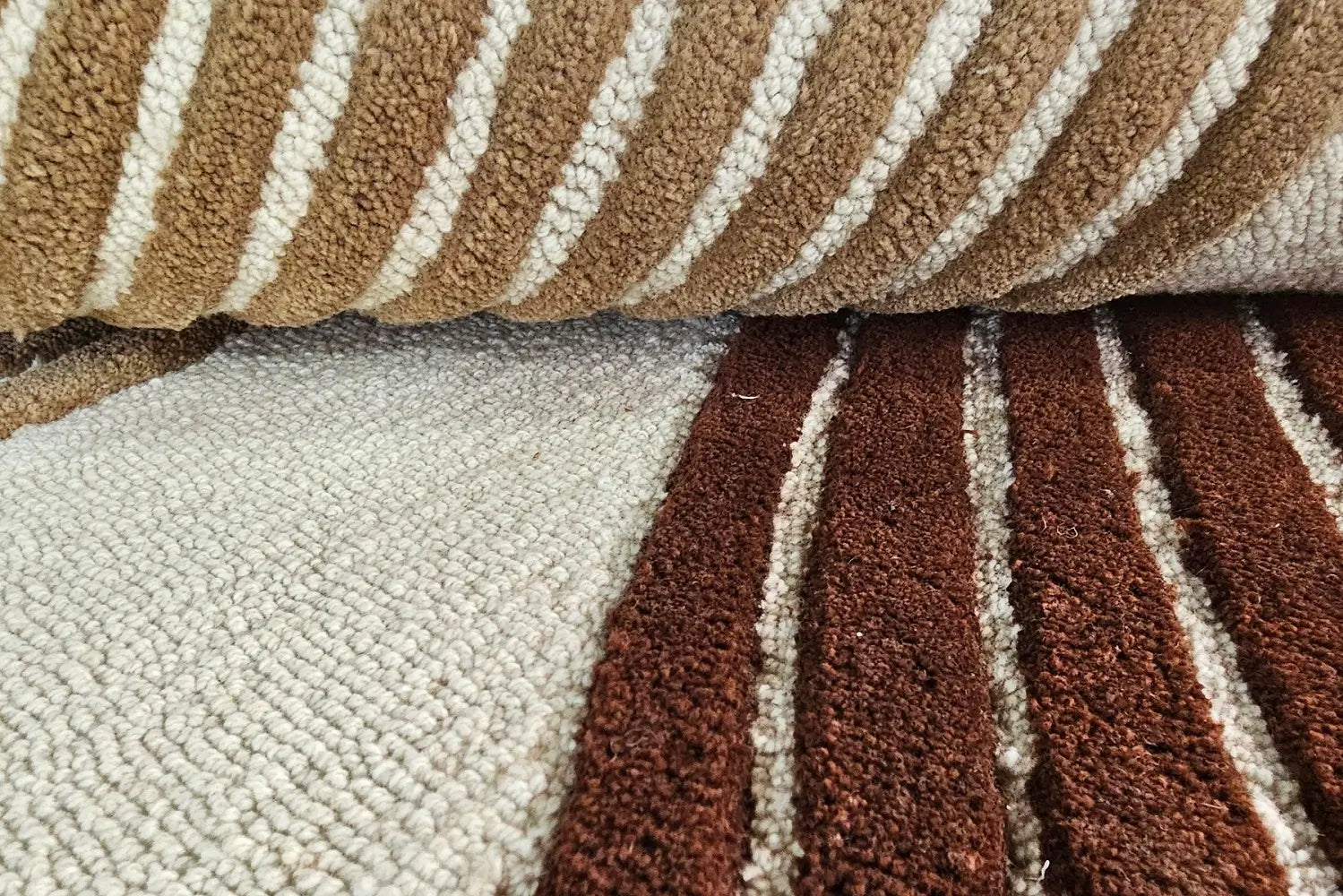 Close-up of a tufted wool rug with brown and beige stripes