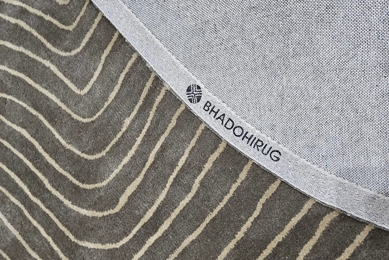 grey round rug, showing backing of the rug