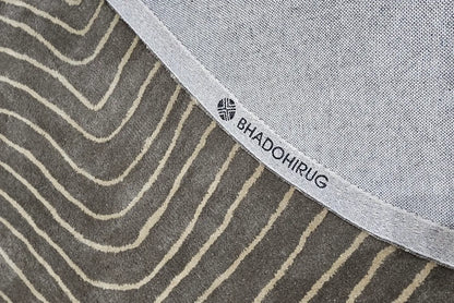 grey round rug, showing backing of the rug