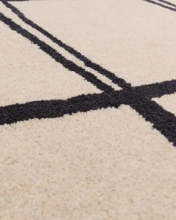 Close-up of a beige carpet with black geometric patterns