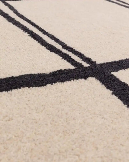 Close-up of a beige carpet with black geometric patterns