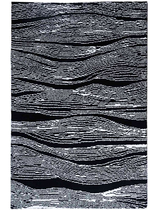 A rectangular area rug with an abstract wavy pattern in black and white